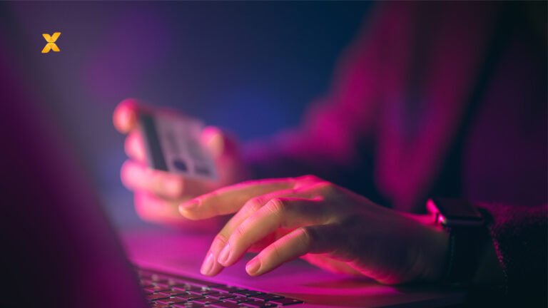 Person typing on a laptop, holding a credit card