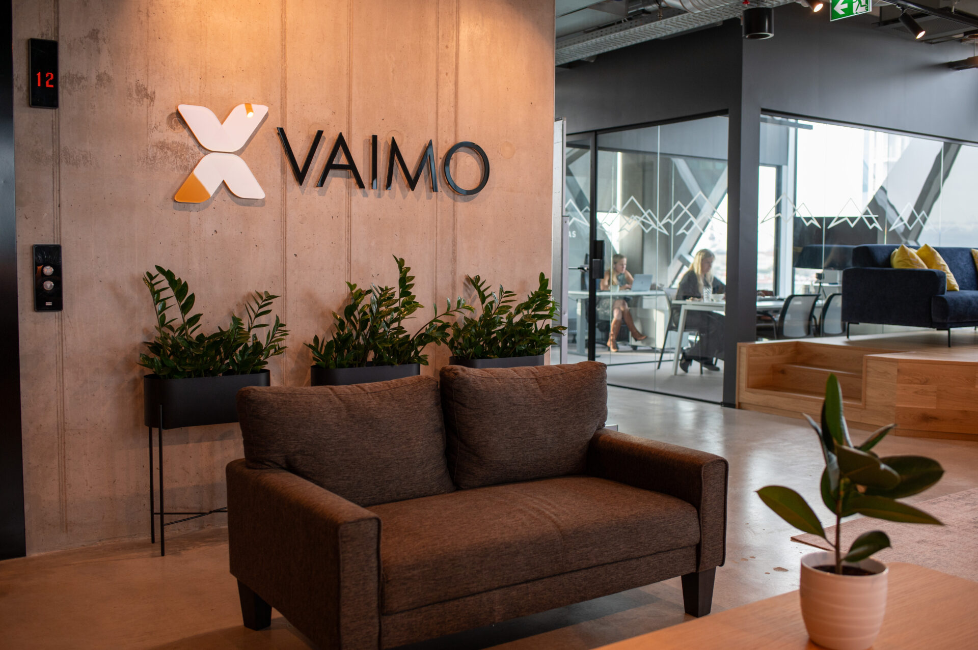 Image of Tallinn office with couch and Vaimo logo on wall