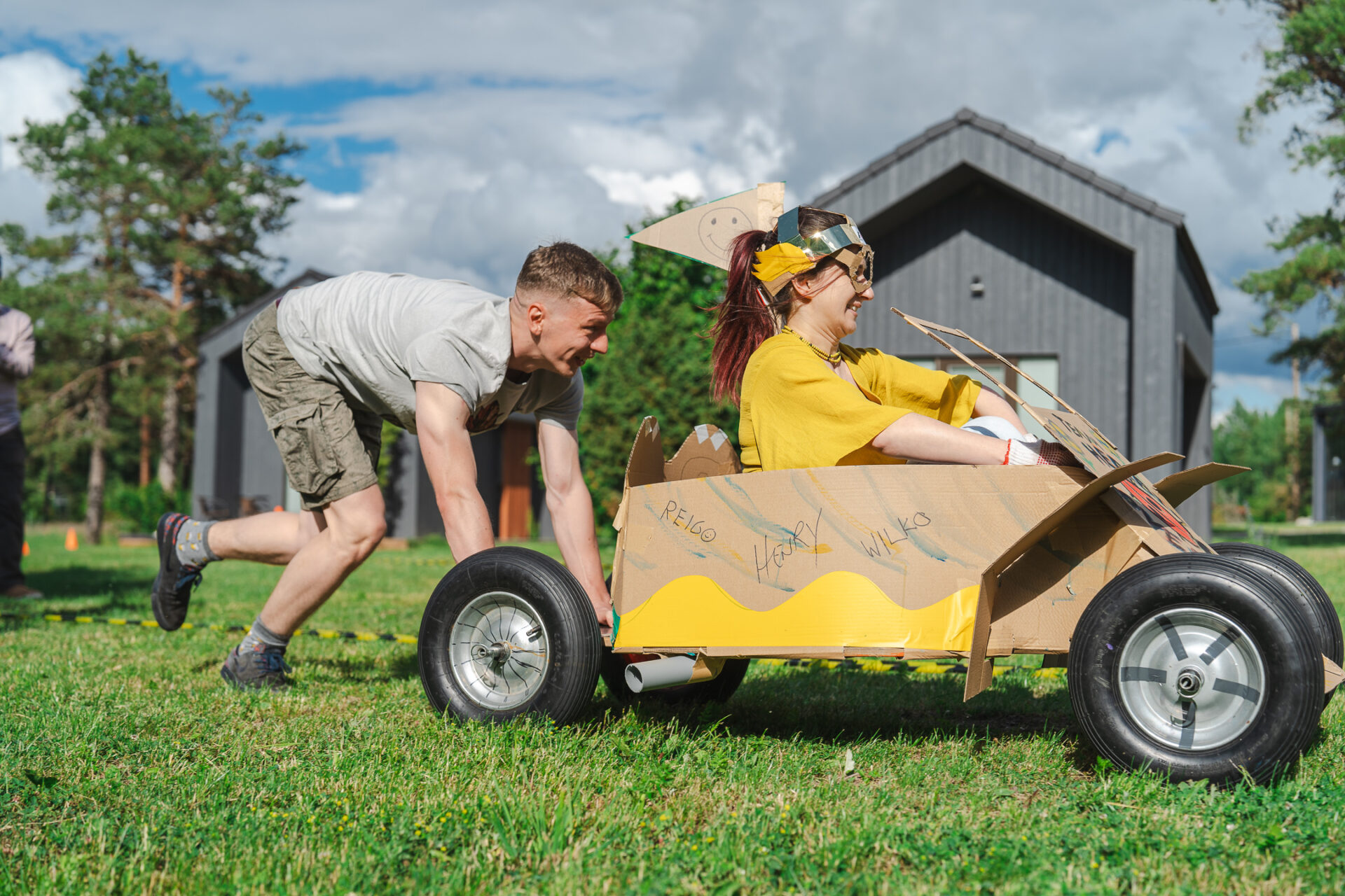 Image of Vaimo employees; one is pushing another in a homemade go-cart