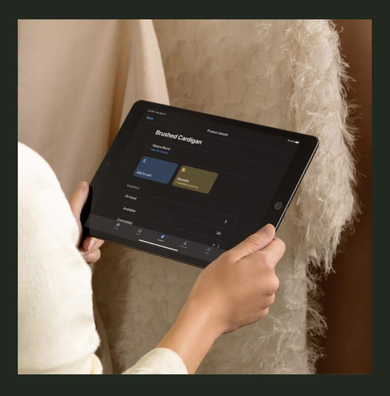 Hands holding a tablet with Shopify on it